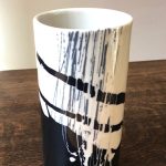 Vase cylindrique, décor d'engobes gris, blanc et noir. Dimensions : diamètre 9 cm x hauteur 18 cm.